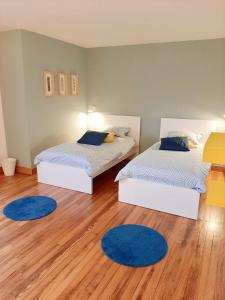 2 camas en una habitación con alfombras azules en el suelo en La villa des Savoyards, en Vielsalm