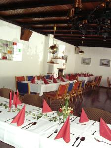 un comedor con mesas y sillas con servilletas rojas en Land gut Hotel Dierks en Repke