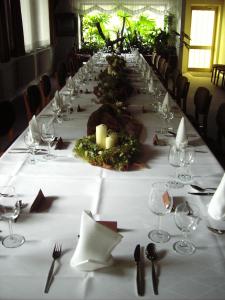 einen langen Tisch mit einem weißen Tischtuch und Weingläsern in der Unterkunft Land gut Hotel Dierks in Repke