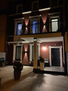 a building with a balcony and a door at night at Oliwa Am Calsberg 5a in Gdańsk