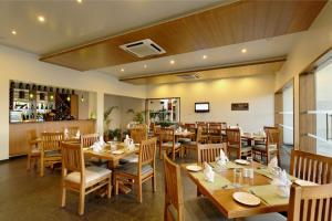 a dining room with wooden tables and chairs at Regenta Resort Soma Vine Village Nashik in Nashik