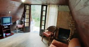 a living room with a fireplace and a tv at Refúgio nas Montanhas in Engenheiro Passos