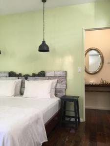a bedroom with a large white bed and a mirror at RIVA B&B in Bocas del Toro