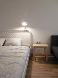 1 dormitorio con 1 cama y 1 mesa con lámpara en Old town center studio en Klaipėda