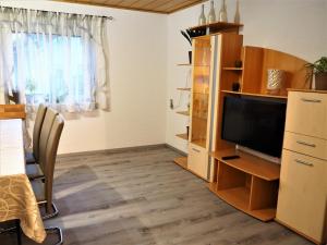 a living room with a flat screen tv and a desk at Dahoam in Salzweg