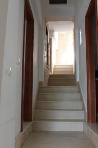 eine Treppe in einem Haus mit weißen Wänden und Holztüren in der Unterkunft Pile Apartments 7 in Omiš