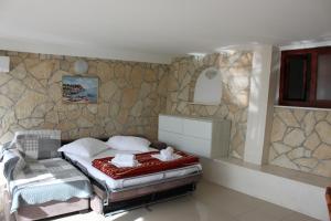 ein Schlafzimmer mit einem Bett und einer Steinmauer in der Unterkunft Pile Apartments 7 in Omiš