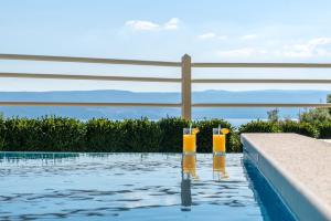 two glasses of orange juice in a swimming pool at Luxury Apartments Tafra in Lokva Rogoznica