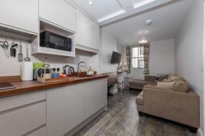 a kitchen and a living room with a couch at Brampton Holiday Homes - Beckside Apartment in Brampton