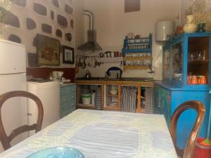 a small kitchen with a table and a refrigerator at Ecoartejeda CAVE HOUSE in Tejeda