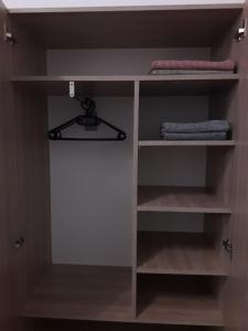 a closet with a wooden shelf with towels on it at Studio apartman Ela in Travnik