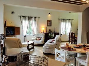 a living room with white furniture and a table at Villa La Patachou in Malaucène