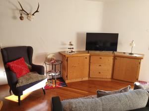 uma sala de estar com televisão numa cómoda de madeira em Haus Moosalm em Berwang