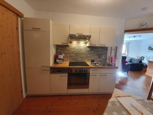 a kitchen with white cabinets and a stove top oven at Haus Moosalm in Berwang