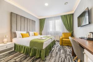 una habitación de hotel con una cama grande y una silla amarilla en Stejarii Resort en Ineu