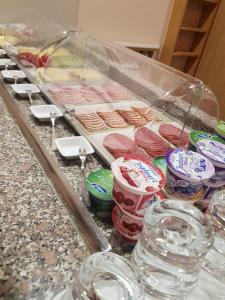 a counter with a tray of different types of meat at Hotel Penterknapp in Bramsche