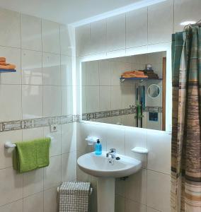Un baño blanco con lavabo y espejo. en Vivienda FRALEMAR Arinaga., en Arinaga