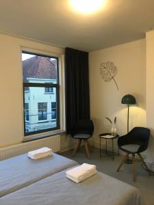 a bedroom with two beds and a large window at Hostel Deventer, Short Stay Deventer, hartje stad, aan de IJssel, in Deventer