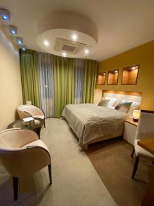 1 dormitorio con 1 cama, escritorio y sillas en Hotel City Park Barlinek en Barlinek