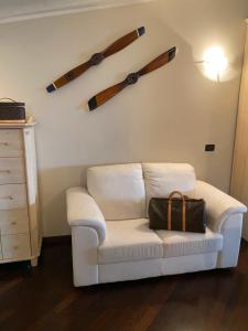 a living room with a white couch and four wooden axes on the wall at Molino Apartments in Desenzano del Garda