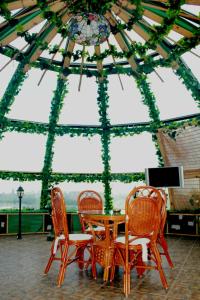 a table and chairs in a room with a ceiling at Naberezhnaya in Novosibirsk