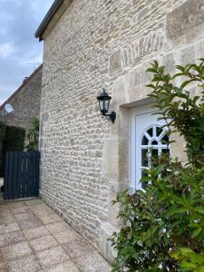 une lumière sur le côté d'un bâtiment en briques avec une fenêtre dans l'établissement cottage Philippe et Valérie, à Silli-en-Gouffern