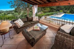 a patio with a couch and chairs and a pool at Finca Es Collet in Felanitx