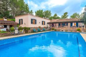 a swimming pool in front of a house at Finca Es Collet in Felanitx