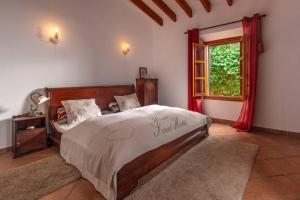 a bedroom with a large bed and a window at Finca Es Collet in Felanitx