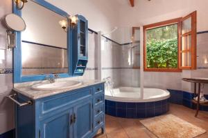 a bathroom with a blue cabinet and a tub and sink at Finca Es Collet in Felanitx +11 photos