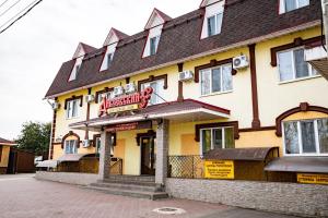 un gran edificio amarillo con un cartel para un restaurante en Diveevskiy Guest House en Diveevo