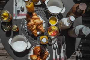 a table with breakfast foods and drinks on it at Domaine Saint Clair - Le Donjon in Étretat
