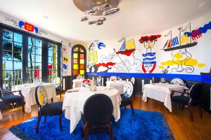 a restaurant with tables and chairs and a mural at Domaine Saint Clair - Le Donjon in Étretat