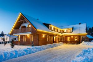 ツベレツにあるApartmány Roháčeの夜の雪の丸太家