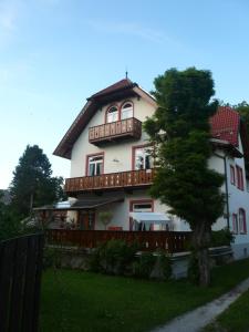 una gran casa blanca con un árbol delante en Apartments Alte Villa, en Garmisch-Partenkirchen