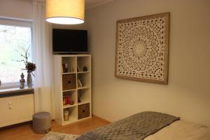 a bedroom with a tv on a wall with a shelf at Ferienapartment Helling in Bad Sobernheim