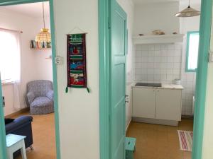 cocina con puerta que da a una sala de estar en Casa do Viajante - Family, en Zambujeira do Mar
