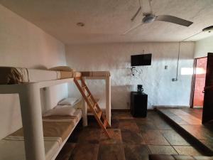 a room with a bunk bed and a flat screen tv at Bungalows La Perla Playa Azul in Playa Azul