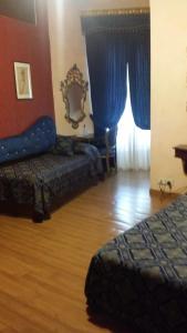 1 dormitorio con 2 camas y una ventana con cortinas azules en Hotel Abaco, en Florencia