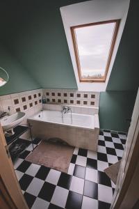 a bathroom with a large bath tub and a window at Pannónia Apartment in Göd