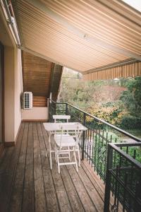 a porch with a table and chairs on a balcony at Pannónia Apartment in Göd