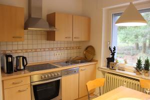 a kitchen with a stove and a sink and a window at Ferienapartment Helling in Bad Sobernheim