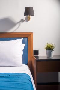 a bedroom with a bed and a table with a lamp at Hotel Aigli in Perea