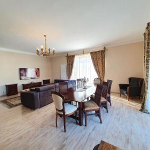 - un salon avec une table, des chaises et un canapé dans l'établissement Vila De la Lugas, à Oradea