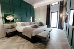 a bedroom with a large bed with a green wall at The Embassy Valletta Hotel in Valletta