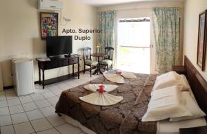 ein Hotelzimmer mit einem Bett mit zwei Platten darauf in der Unterkunft Grimms Pousada de Contos in Porto de Sauipe