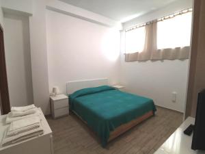 a bedroom with a green bed and a window at All' Ombra del Faro - Mini Apartments in Taranto