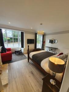 a bedroom with a large bed and a red couch at Charnwood Regency Guest House in Loughborough