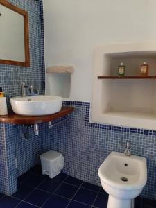 a blue tiled bathroom with a sink and a toilet at Guesthouse Contrada Bolla in Finale Ligure