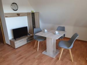 een eetkamer met een tafel en stoelen en een tv bij Astenkick FeWo Altastenberg 500 Meter in Winterberg